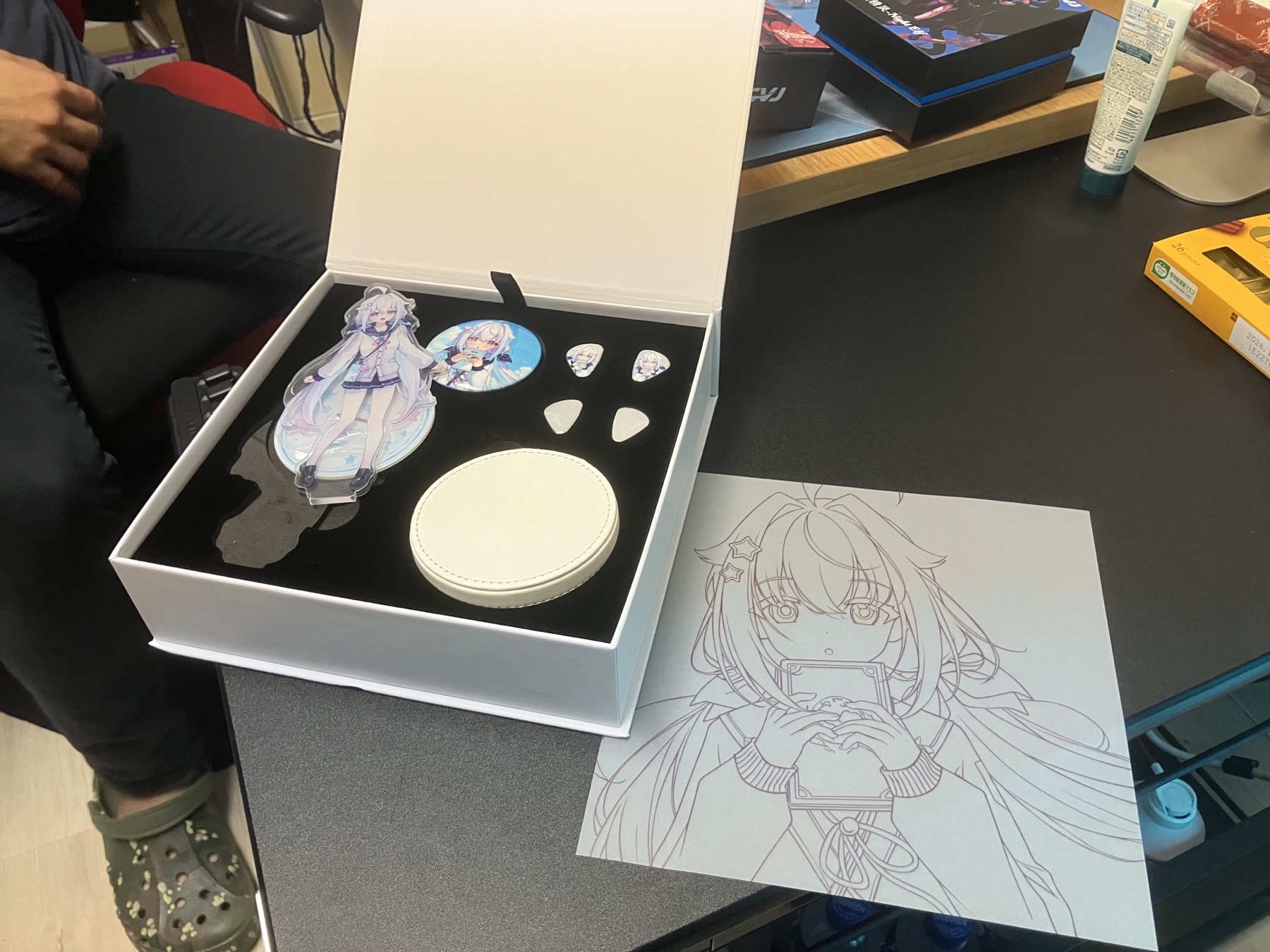CVJ NOZOMIの箱に収められたイヤホン、アクリルスタンド、缶バッジ、ケース、交換用フェイスプレート