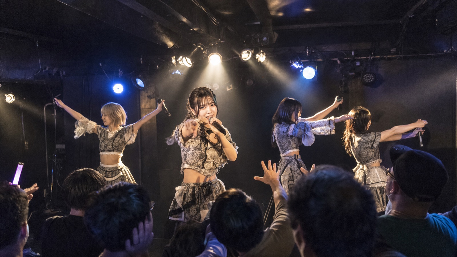 小規模ライブハウスでステージを見つめる観客のイメージ