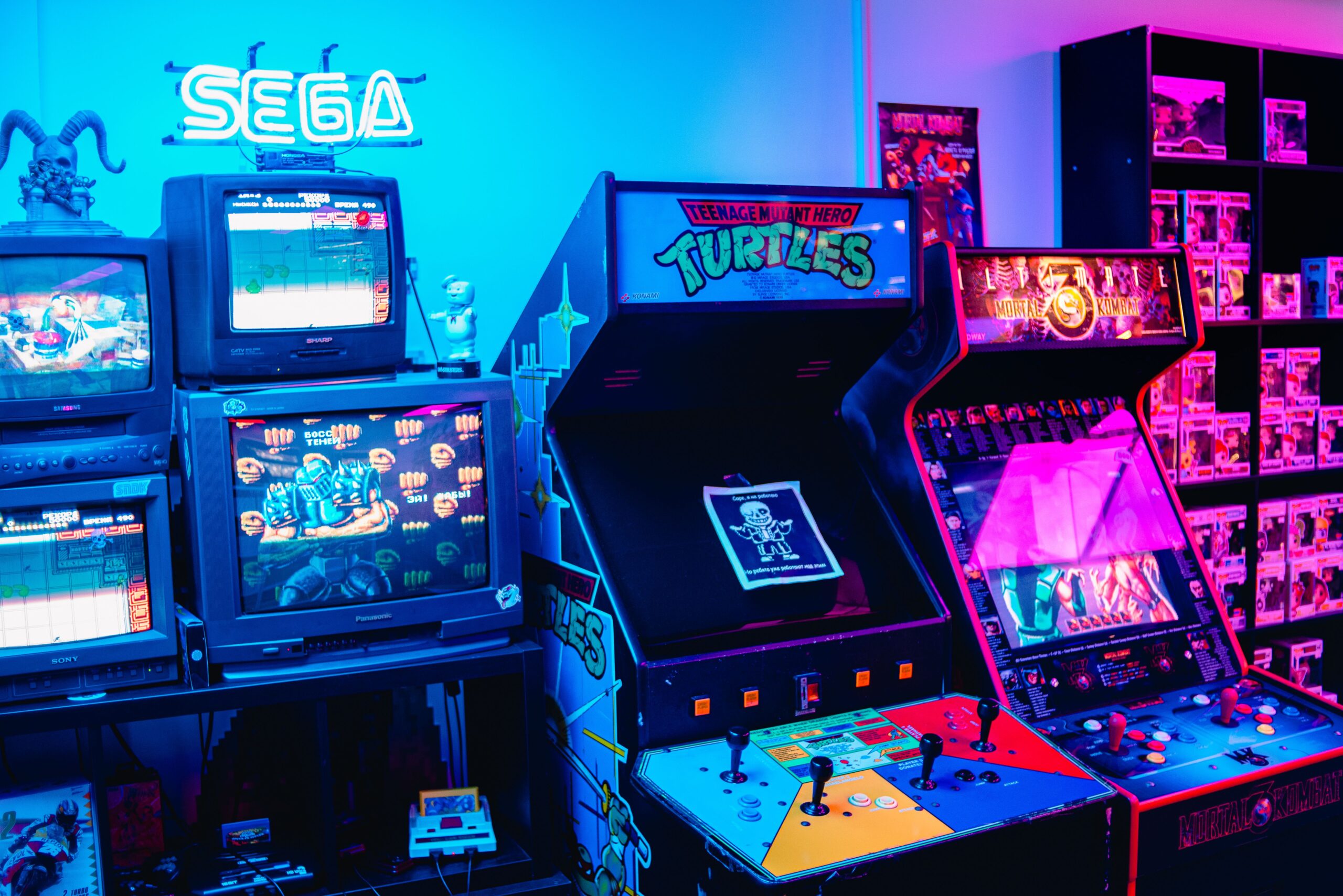 青とピンクのネオンに照らされたレトロなゲーム機が並ぶ室内